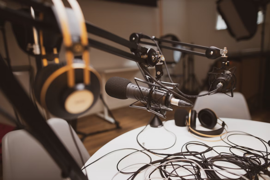 empty podcast studio with headphones hanging and microphones